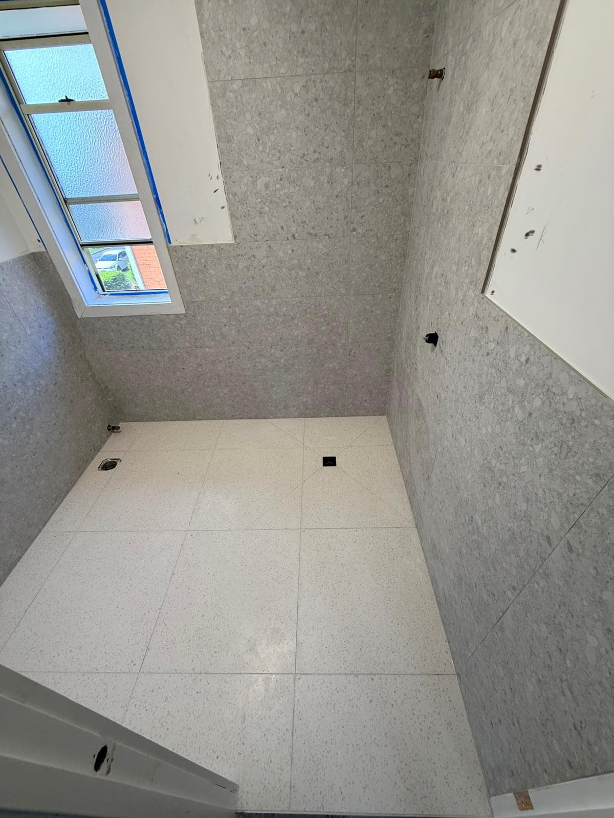 Bathroom with curved glass shower and tiled surround